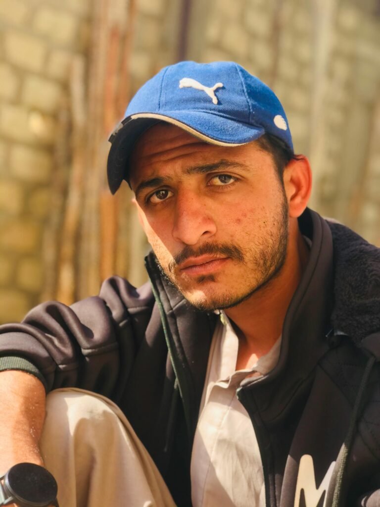 Casual portrait of a man in a blue cap, captured outdoors in natural light.